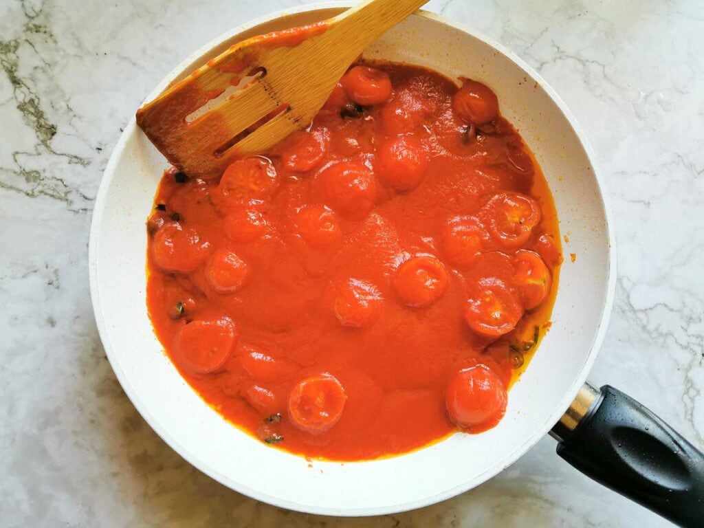 tomato passata in frying pan with other arrabbiata sauce ingredients
