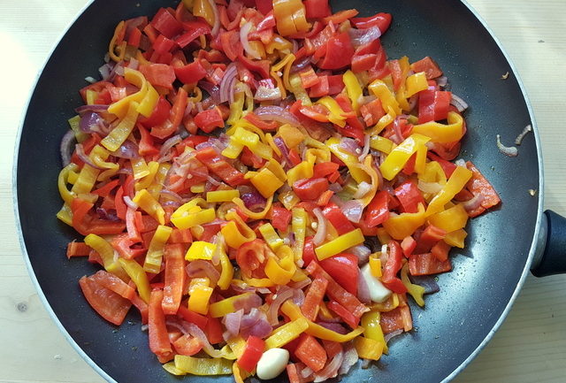 sweet peppers, garlic and onions cooking in frying pan