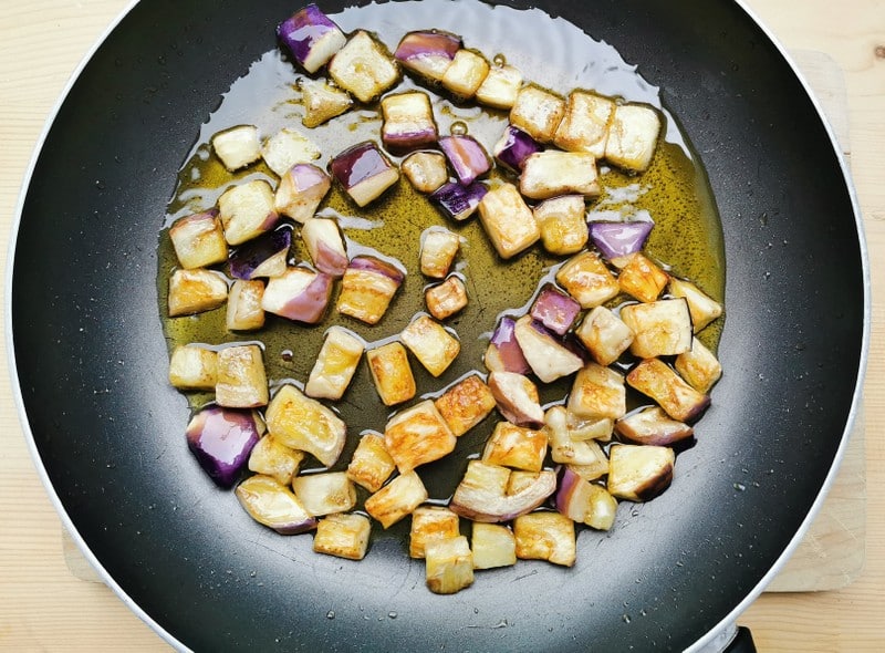 cubed eggplant frying in olive oil in  skillet 