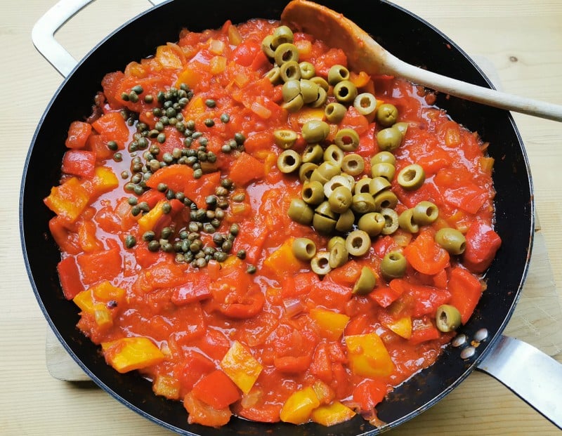 chopped green olives and small capers with caponata sauce in skillet