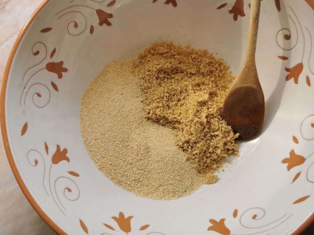 breadcrumbs and crushed walnuts in a white and terracotta bowl