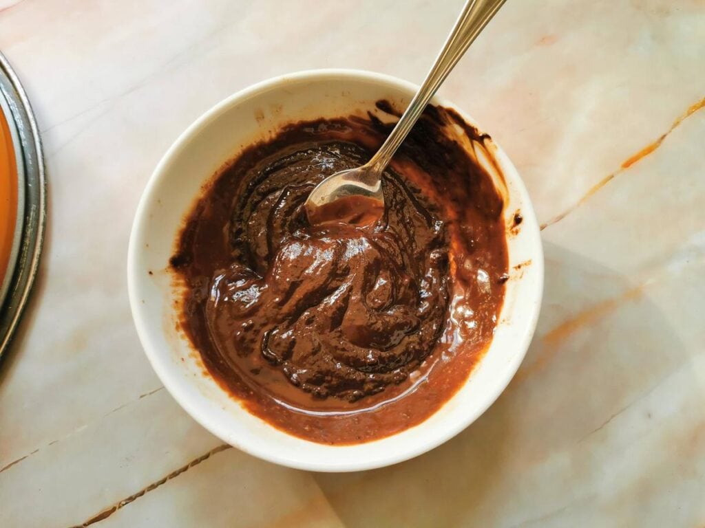 melted dark chocolate in white bowl