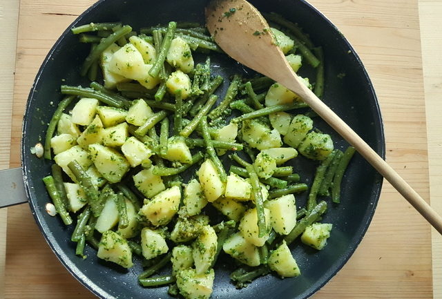 boiled potatoes, green beans and pesto in frying pan for pasta Liguria