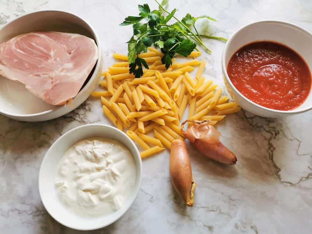 Ingredients for penne al baffo on marble table.