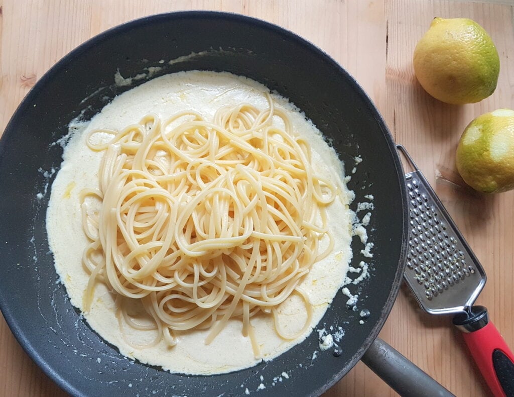 cooked linguine in pan with lemon sauce