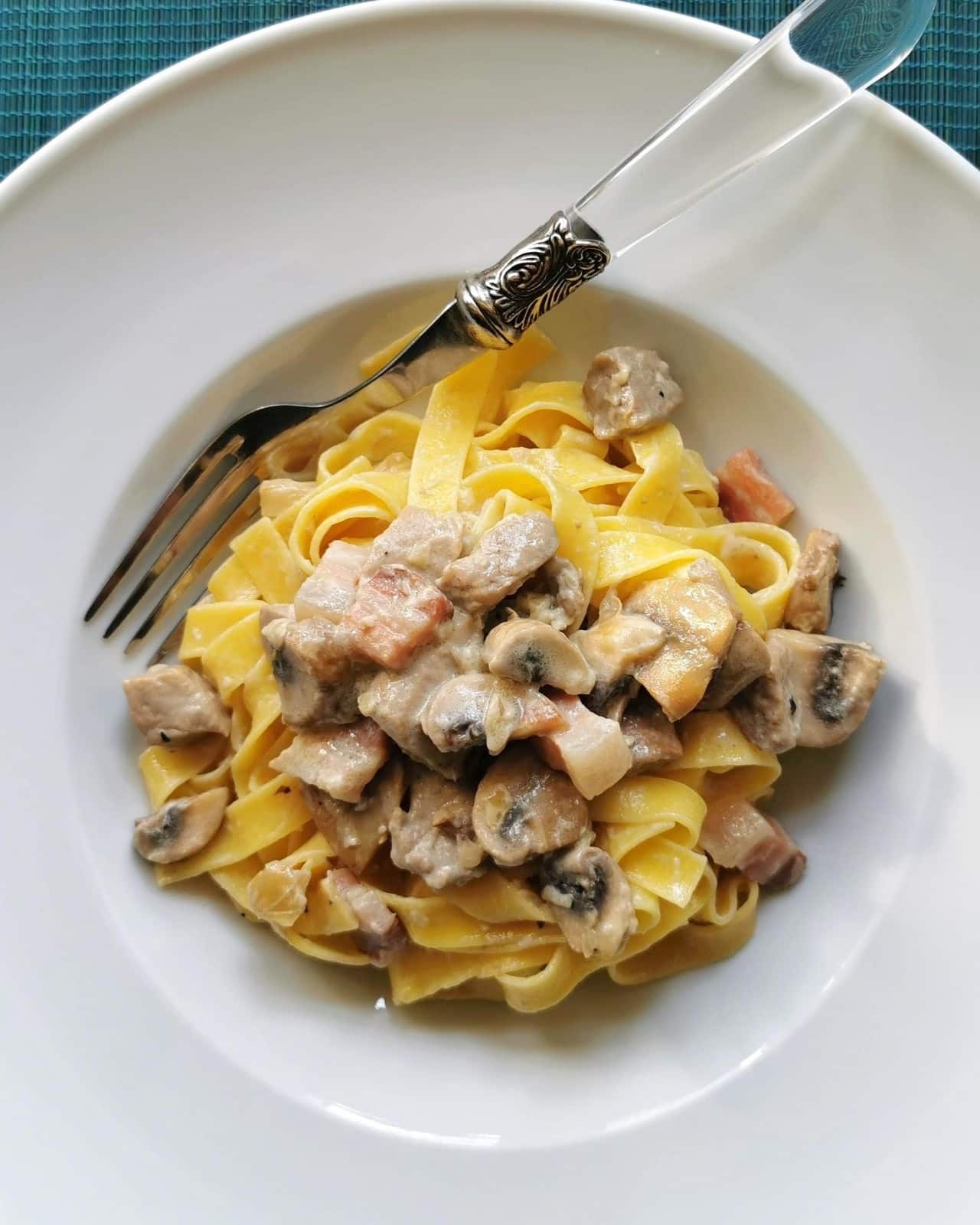 Pork tenderloin pasta in a bowl with a fork.