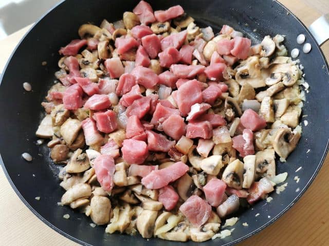chopped pork fillet (tenderloin) in skillet with other sauce ingredients