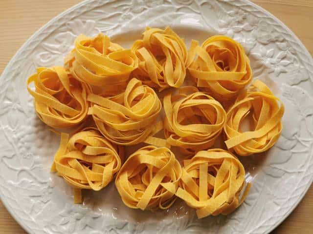 dried egg tagliatelle nests on white plate