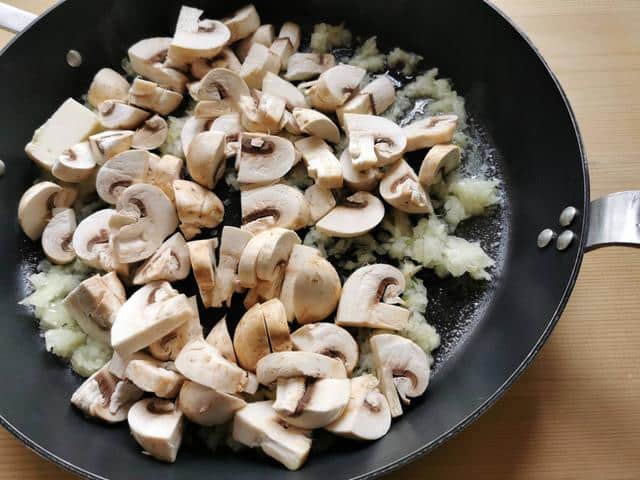 mushrooms, onions, garlic and butter cooking in skillet