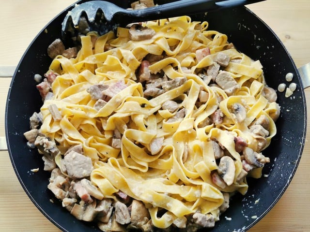tagliatelle mixed with the pork fillet sauce in skillet before serving