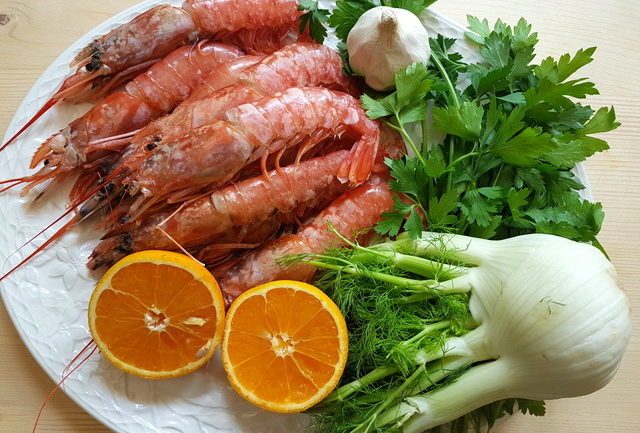 ingredients on white plate for farfalle pasta with prawns and oranges 