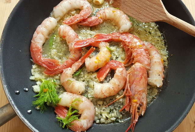 Prawns cooking in frying pan for farfalle pasta with prawns and orange recipe