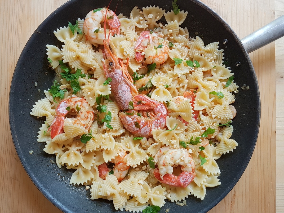 Pasta added to the prawns and orange sauce.