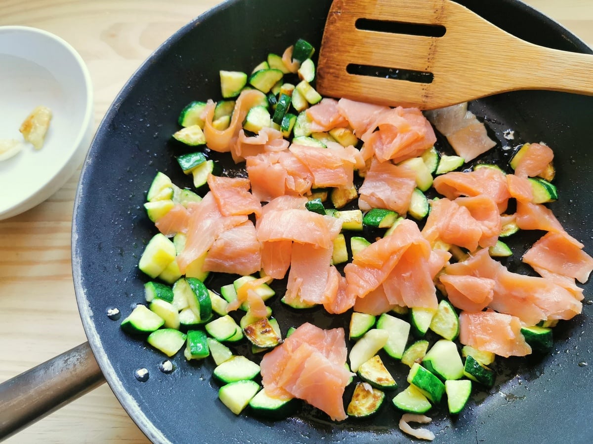 pieces of smoked salmon in skillet with zucchini pieces