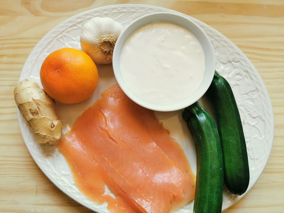 ingredients for farfalle pasta with smoked salmon and zucchini on white plate