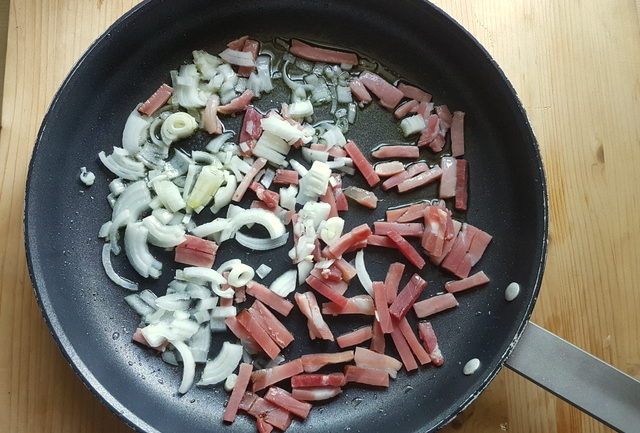 Onions and speck in frying pan for pasta with speck and radicchio recipe