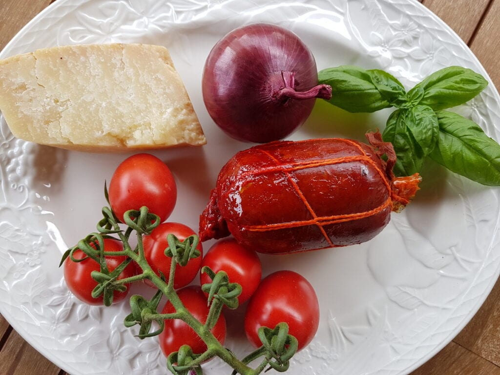 ingredients for spicy pasta with nduja on white plate.