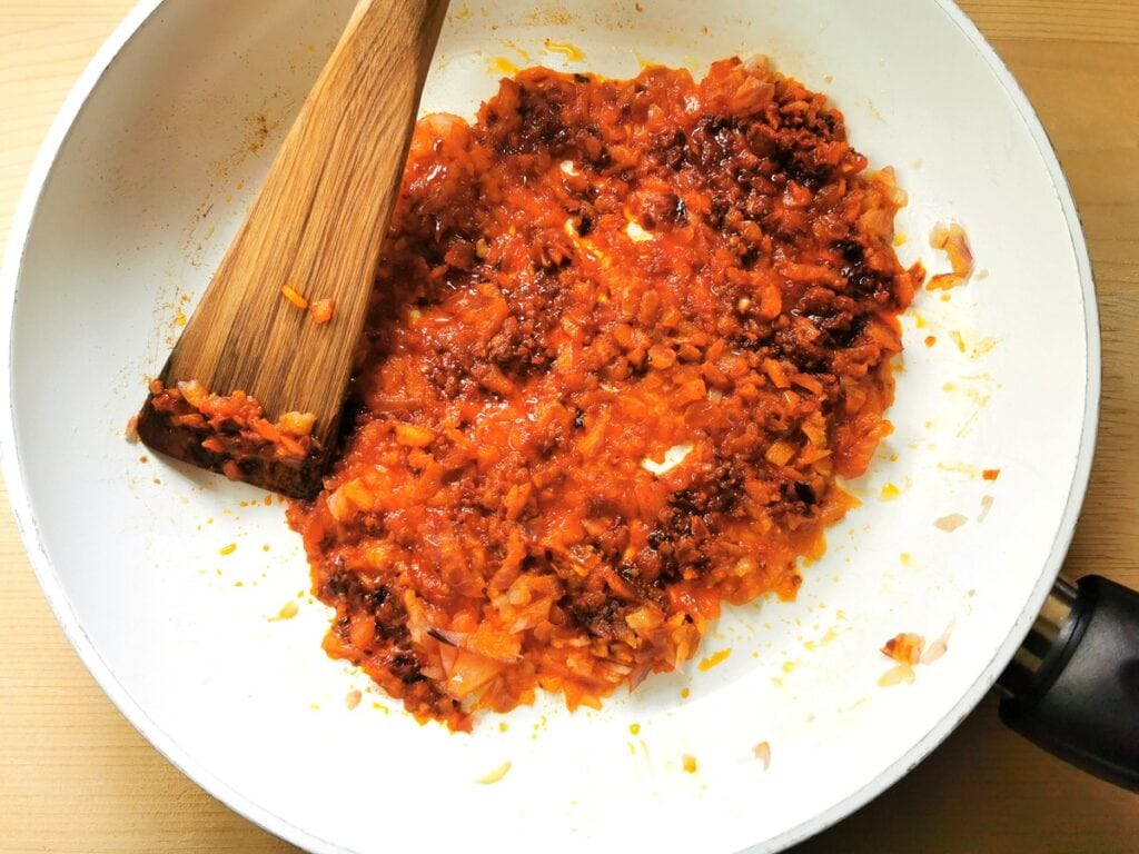 nduja mixed with chopped onions cooking in pan