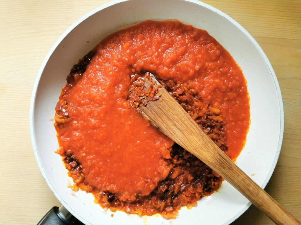 tomato passata added to pan with nduja and onions