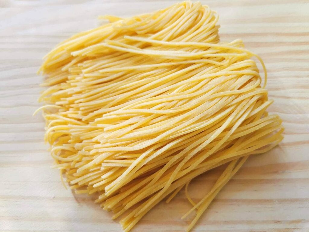 fresh tagliolini on wooden board