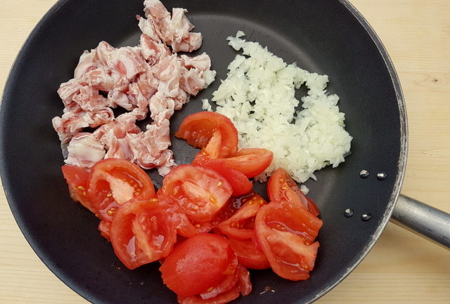 pancetta, onions and peeled and chopped tomatoes in frying pan