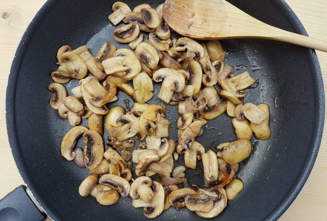 sliced mushrooms, garlic and shallot cooking in frying pan