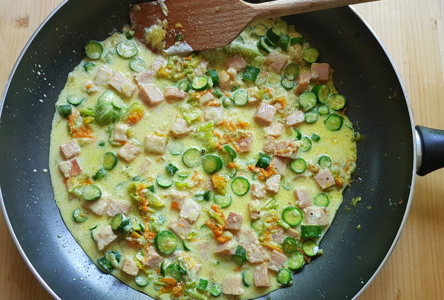 sauce in frying pan for pasta with zucchini flowers, saffron and ham