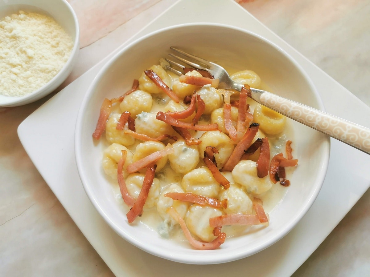 Gnocchi with gorgonzola in a white bowl.