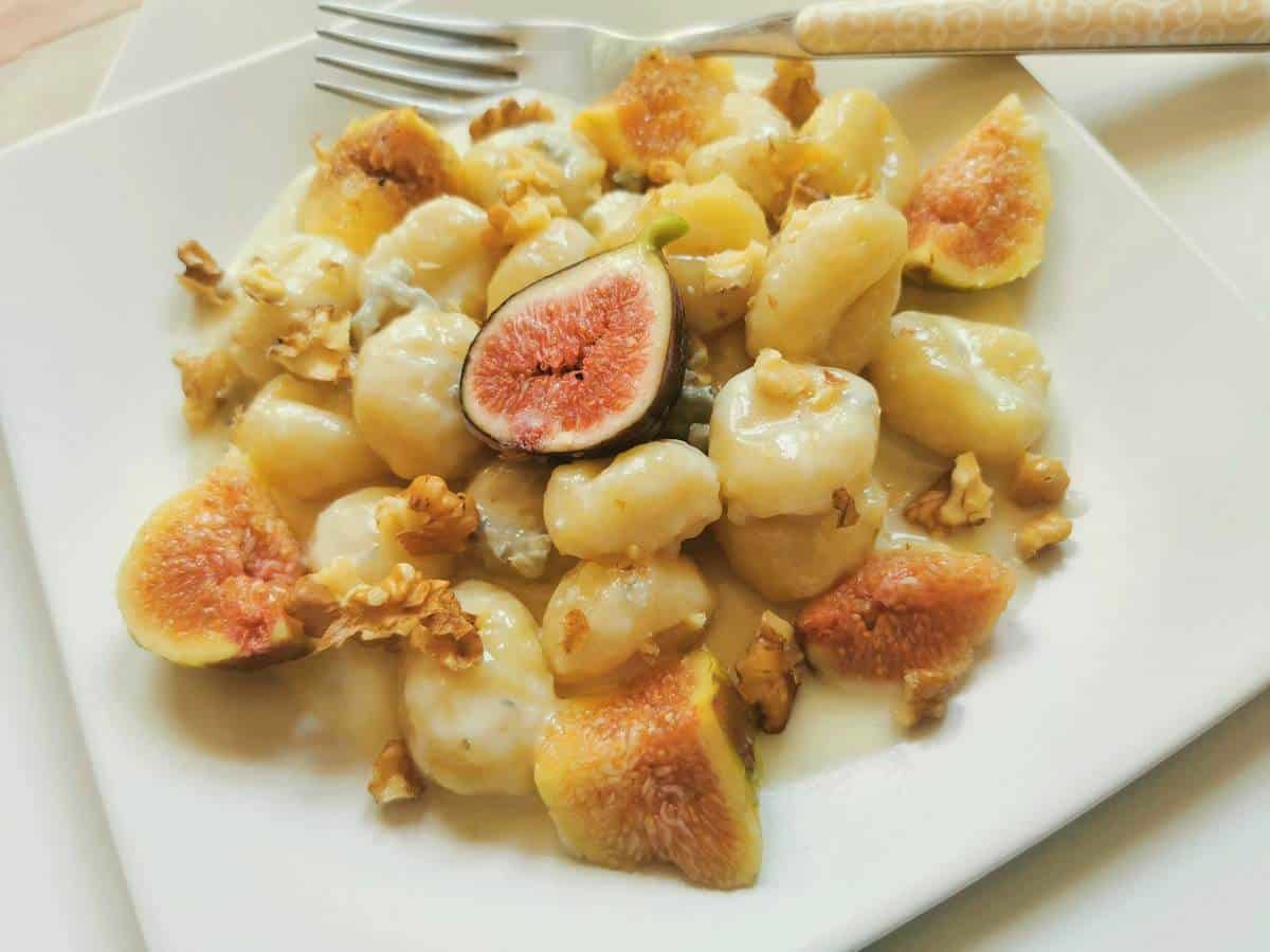 Gorgonzola gnocchi on a plate with walnuts and figs.