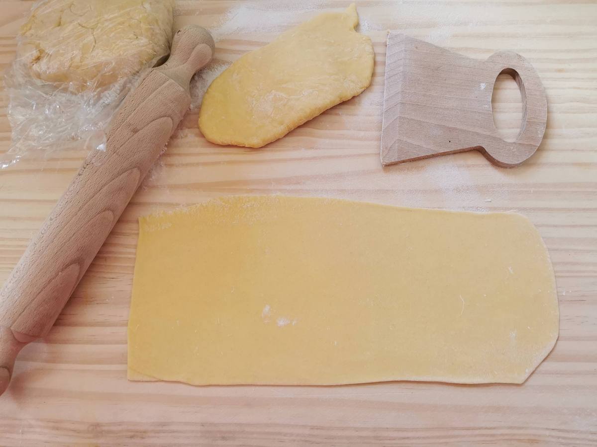 Rectangular fresh pasta sheet on wood work surface.