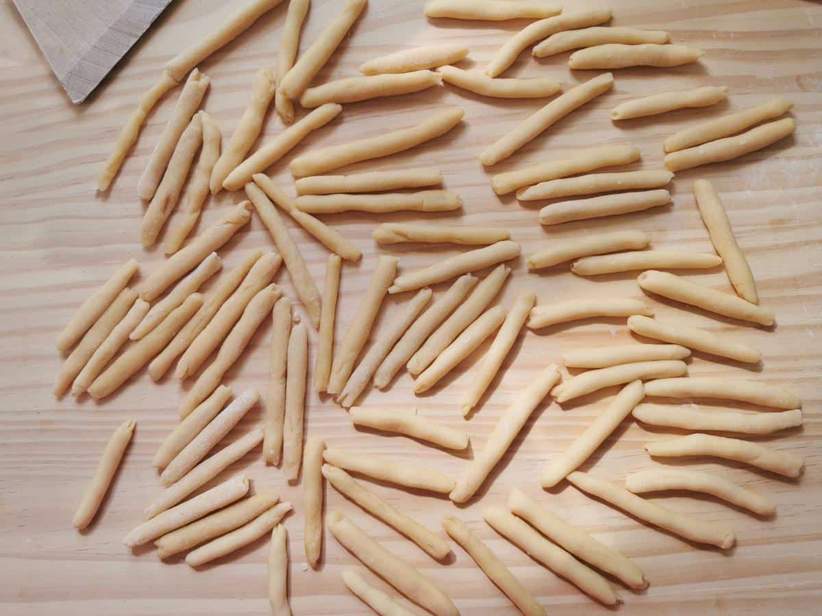 Homemade maccheroni (macaron del frèt) on wood work surface.