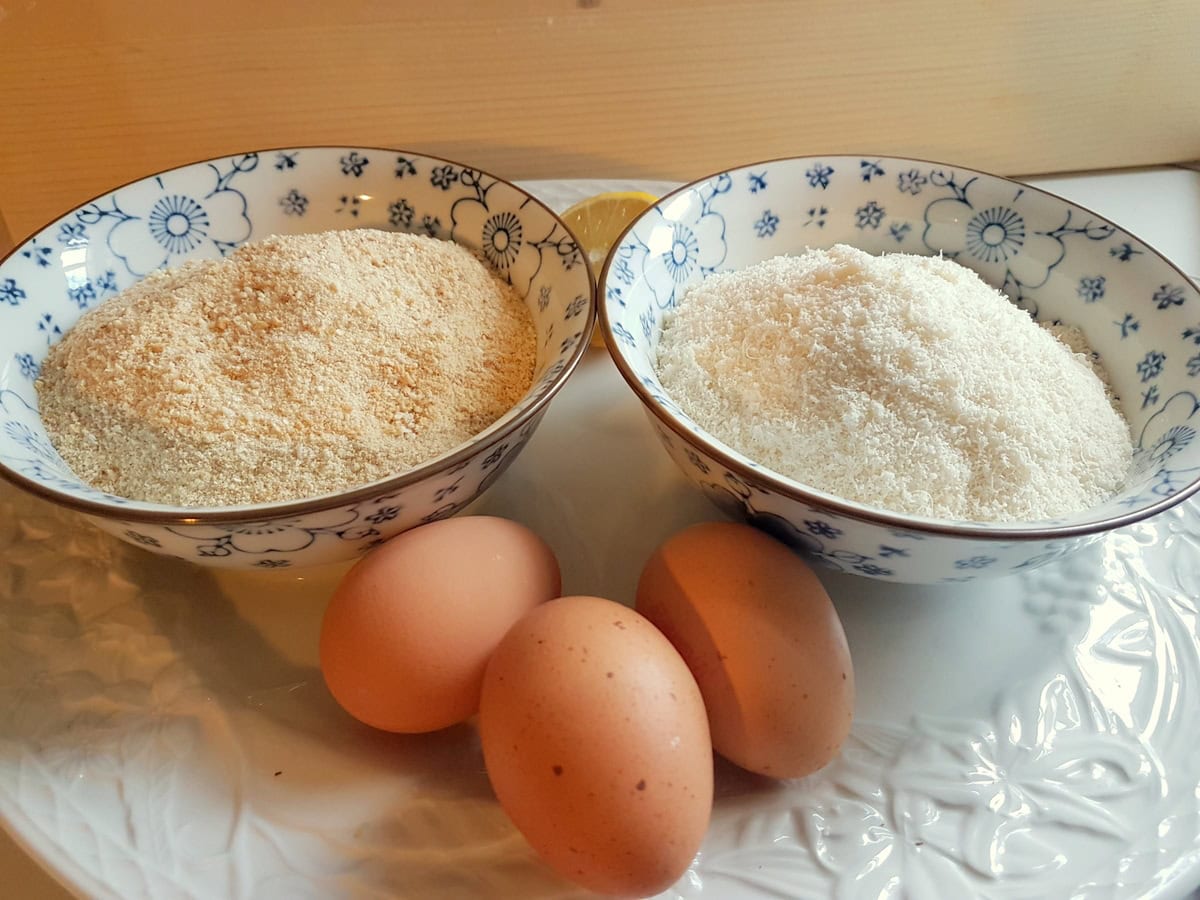 Breadcrumbs and grated Parmigiano in 2 small bowls, 3 eggs and a lemon.