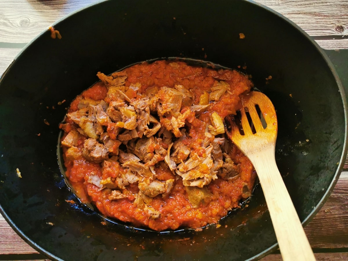 Duck meat removed from bones and added back to the sauce in Dutch oven.