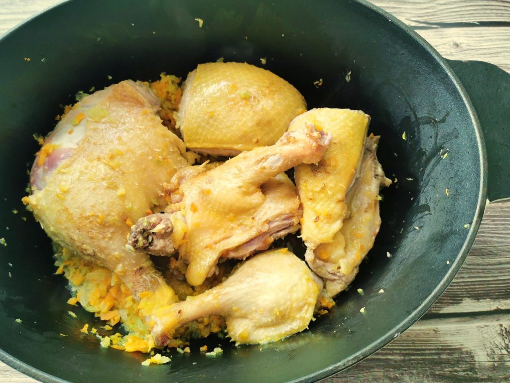 duck pieces in Dutch oven with vegetables