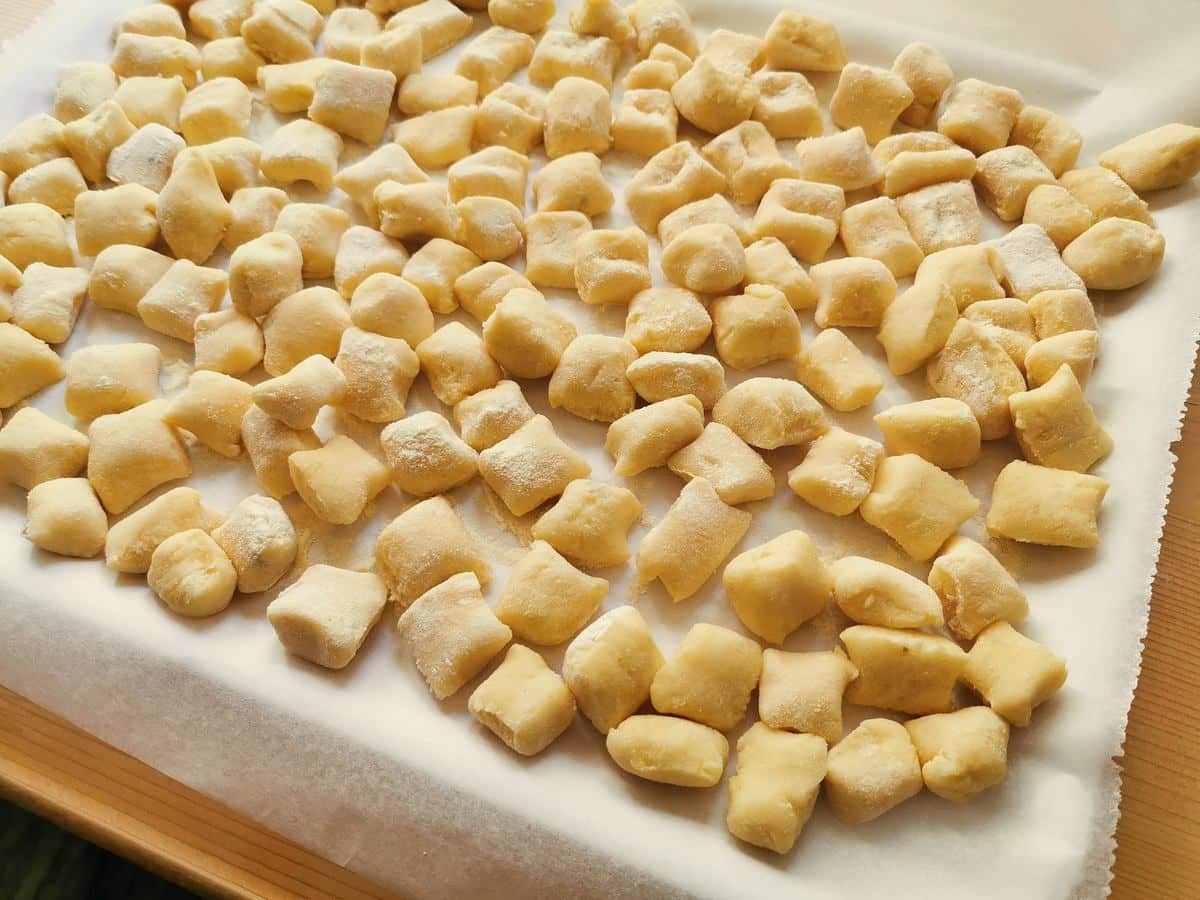 Ready uncooked potato gnocchi on floured tray