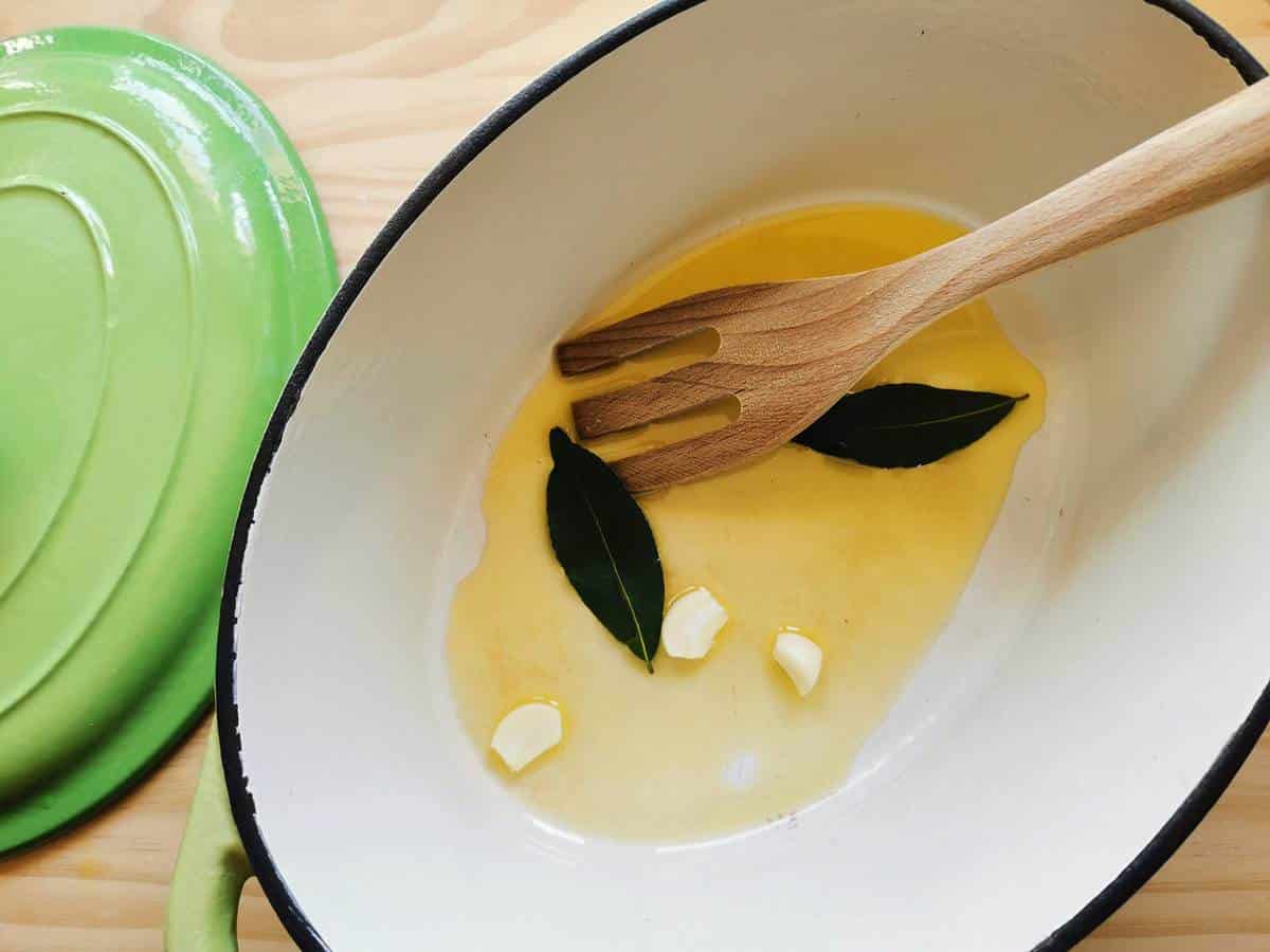 Garlic, bay leaves and olive oil in a pot.