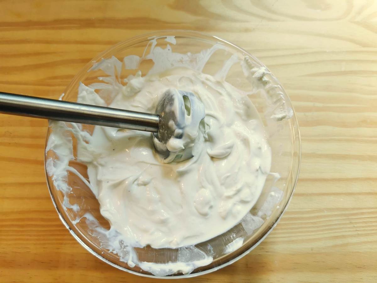 Creaned ricotta in glass bowl with immersion blende.