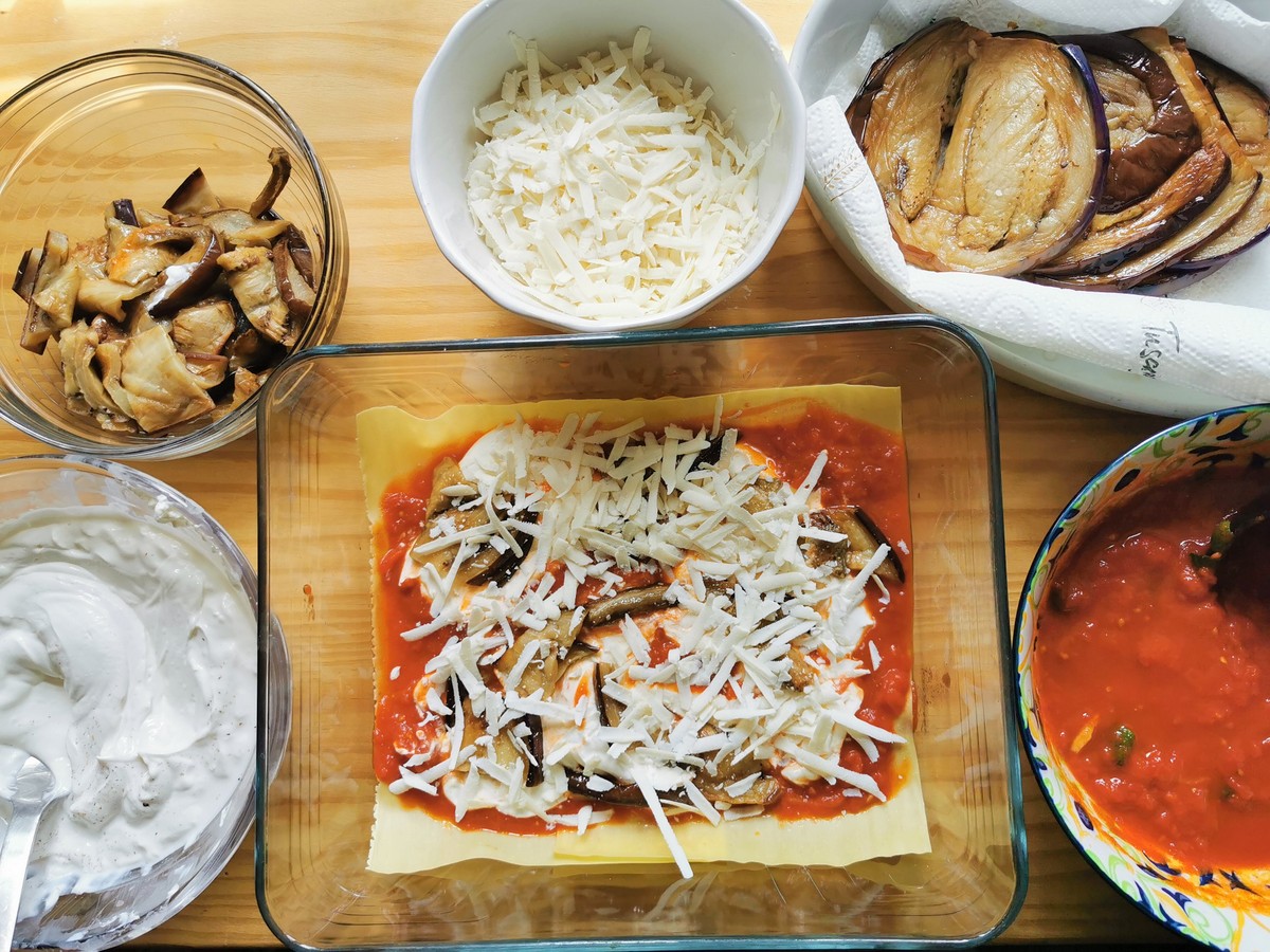 Grated ricotta salata on top of lasagna layer made with lasagne sheets, tomato sauce,, ricotta cream and pieces of eggplant.