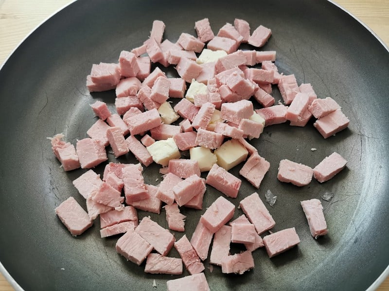 cubes of cooked ham in skillet with butter