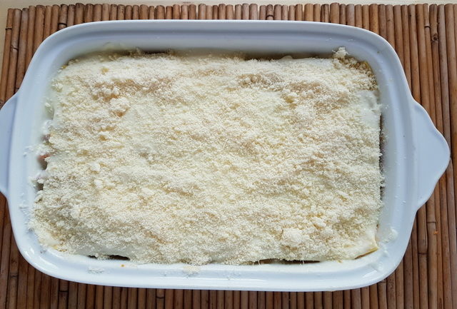 lasagne al forno with bolognese in white oven dish ready for baking