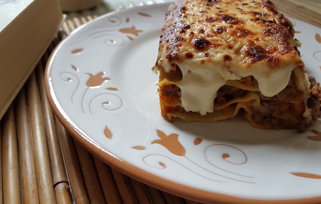 lasagne al forno with bolognese on white terracotta plate