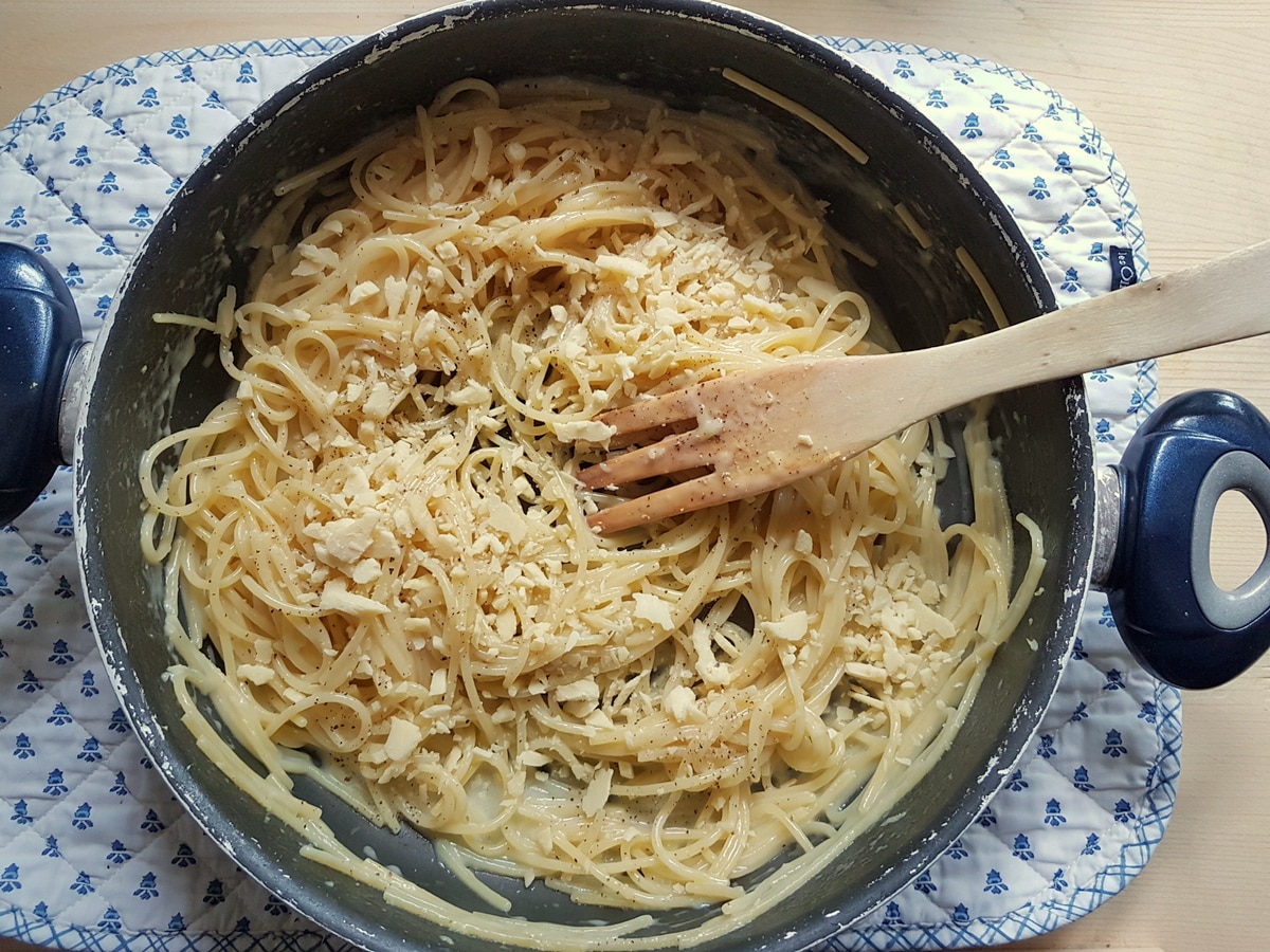 Cheese being mixed into the lemon pasta sauce.