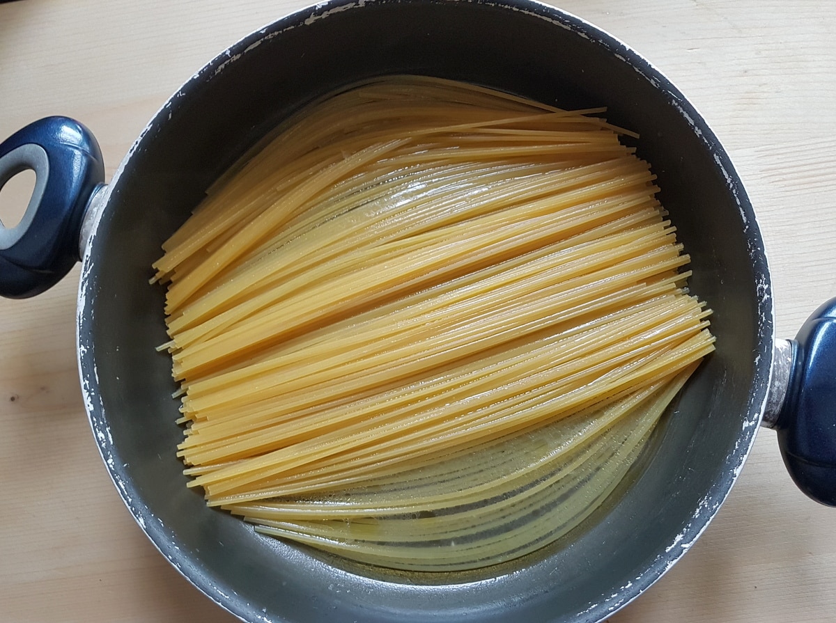 Spaghetti cooking in a pan of lemon infused water.