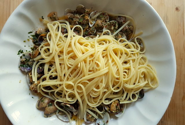 Clam sauce and pasta for linguine pasta alle vongole (linguine with clams ) in white bowl