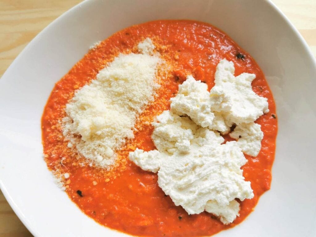 blended pesto Calabrese sauce in white bowl with added ricotta and grated pecorino