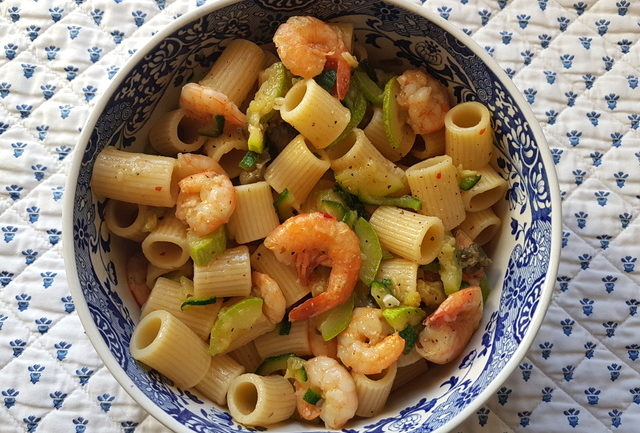 mezze maniche pasta with zucchini and prawns in blue and white serving dish