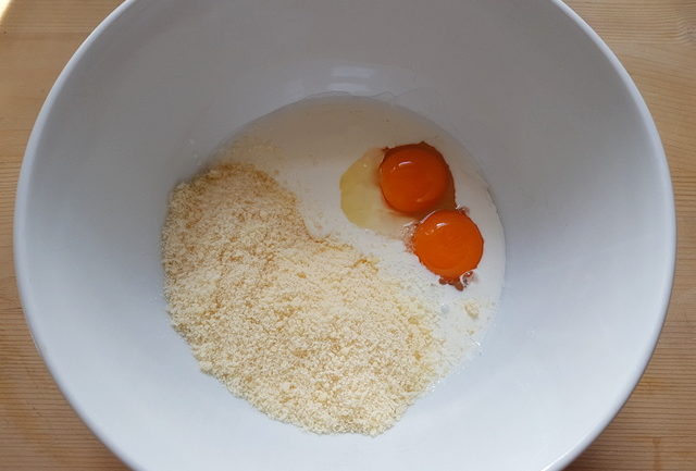 cream, eggs and grated parmigiano in white bowl