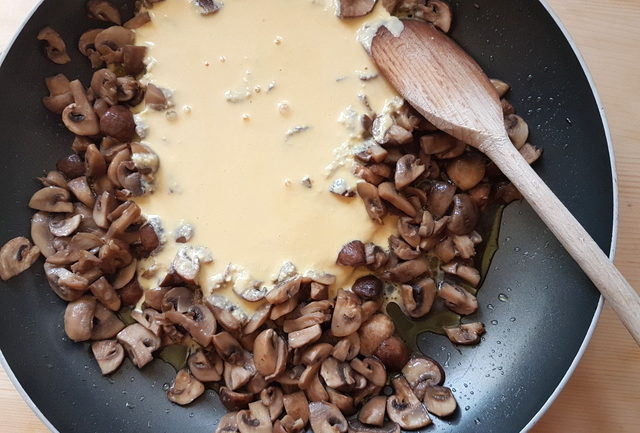 cooked mushrooms with cream, egg and cheese sauce in frying pan