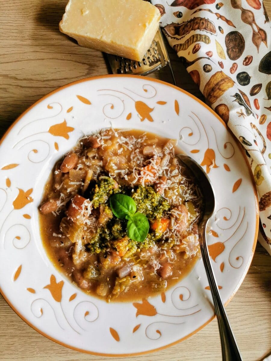 Minestrone with pesto in soup bowl with spoon.