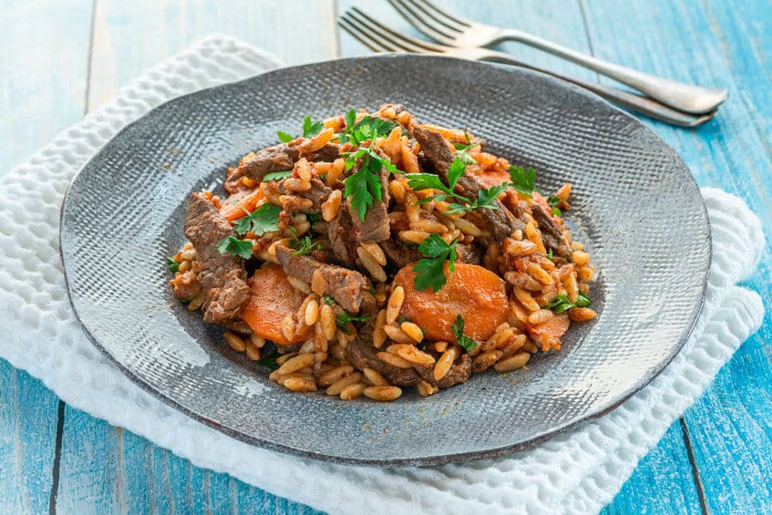 Giouvetsi - traditional Greek baked dish with beef and orzo pasta in tomato sauce.